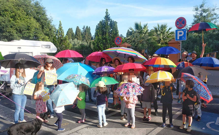 Familias del CEIP Algafequi protestan con sombrillas, paraguas y pamelas por la falta de sombras en el centro