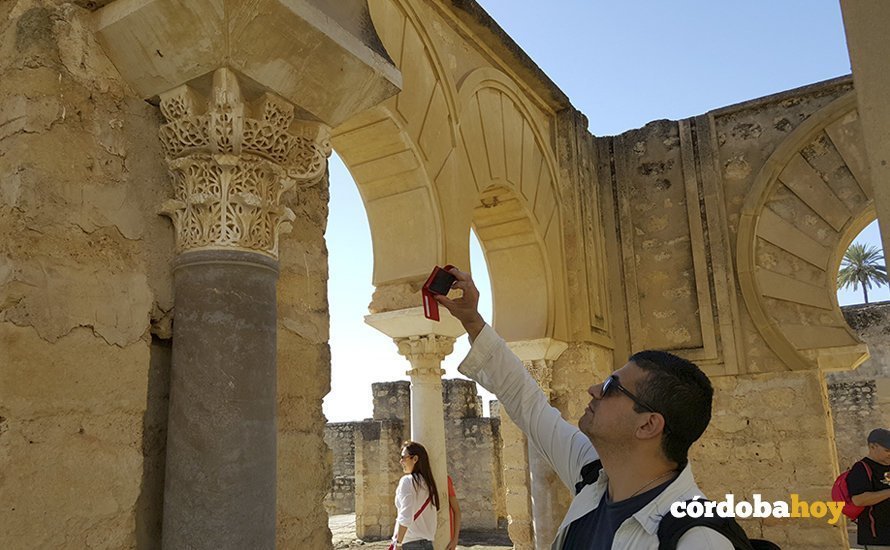Un turista fotografía un capitel de Medina Azahara