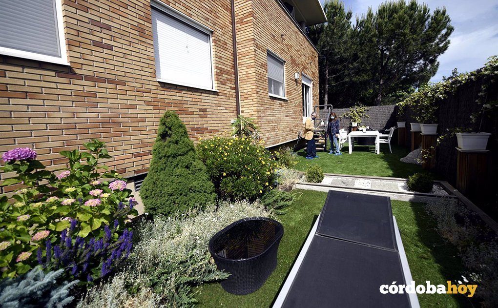 El director de una inmobiliaria le enseña el jardín de una casa a una clienta