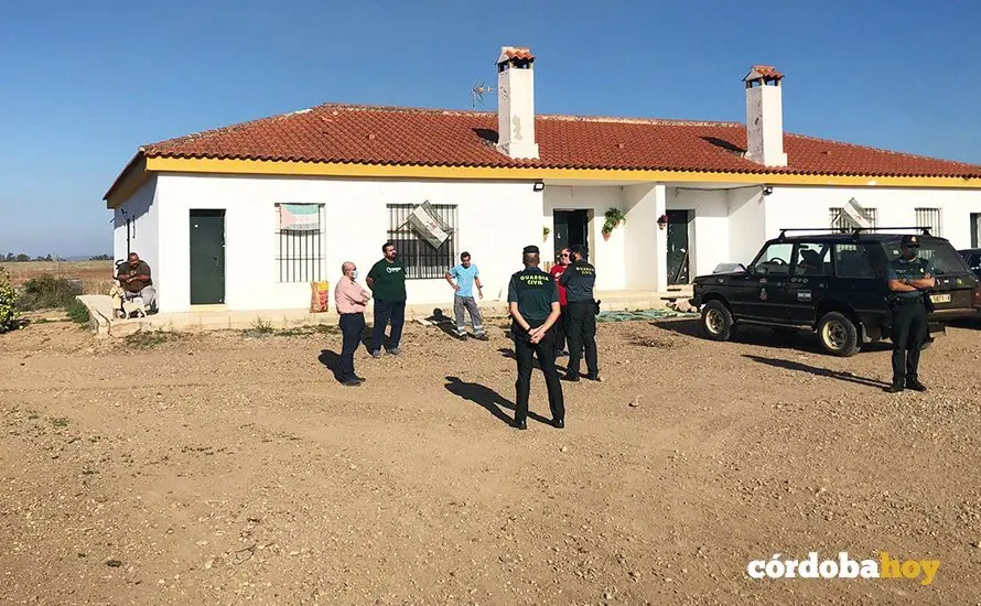 Agentes de la Guardia Civil conversan con &Oacute;scar Reina (de verde) antes del desalojo de la finca Somonte
