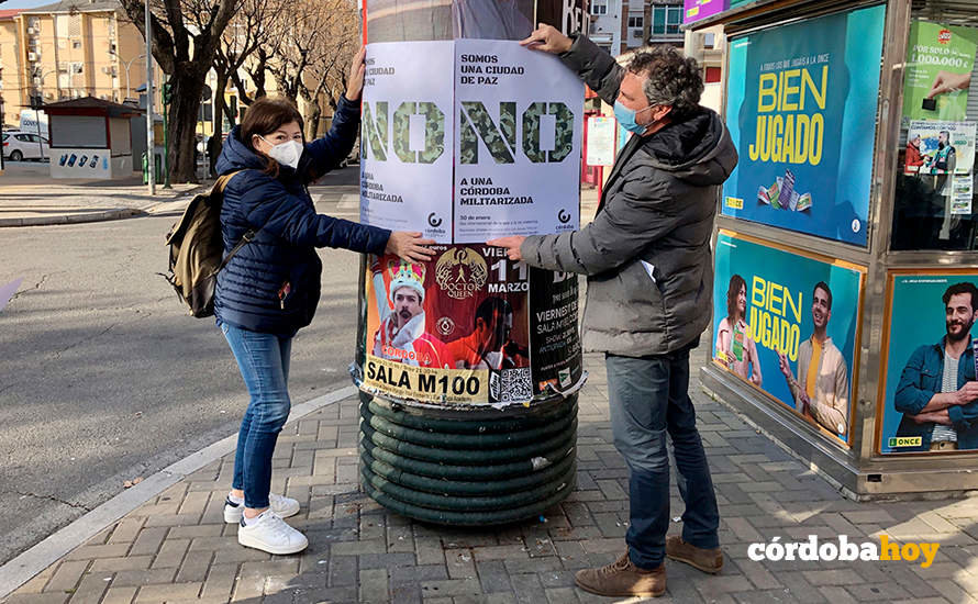 Pegada de carteles de Córdoba en Común contra la Base Logística