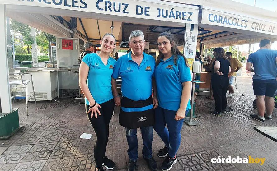 Rafael Mu&ntilde;oz Soro ante su puesto de caracoles en Cruz de Ju&aacute;rez junto a Lorena y Cristina
