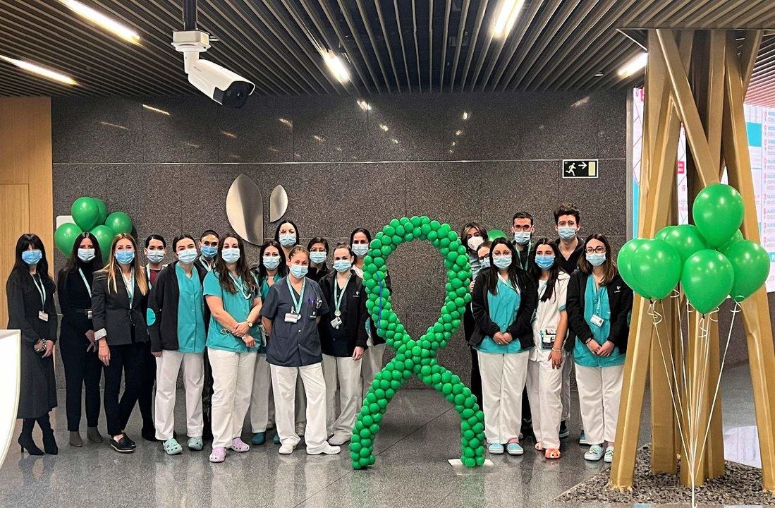 Profesionales del Hospital Quirónsalud Córdoba junto a globos y lazo de color verde, que representa la lucha contra el cáncer