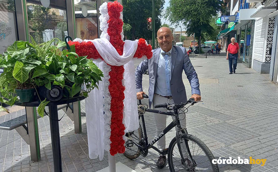 Antonio Hurtado con su bicicleta junto a una Cruz de Mayo