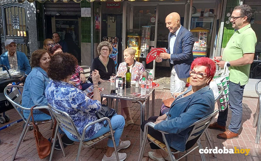 Hurtado reparte propaganda electoral a un grupo de mujeres en la terraza de una cafetería