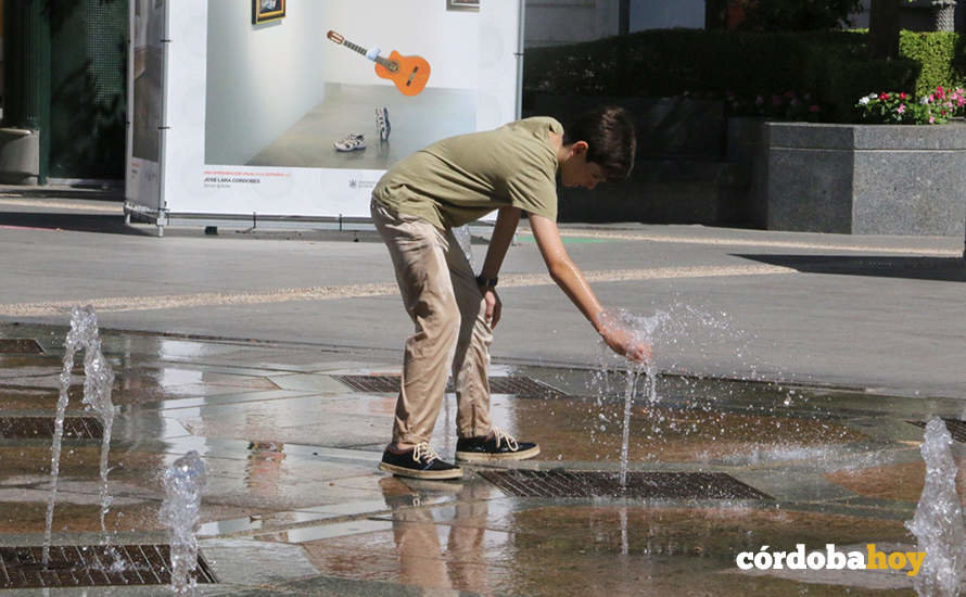 Un chico se refresca en los chorros de agua de la Plaza de Las Tendillas de Córdoba
