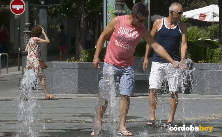Dos hombres tratan de refrescarse en los chorros de Las Tendillas, en una foto de archivo