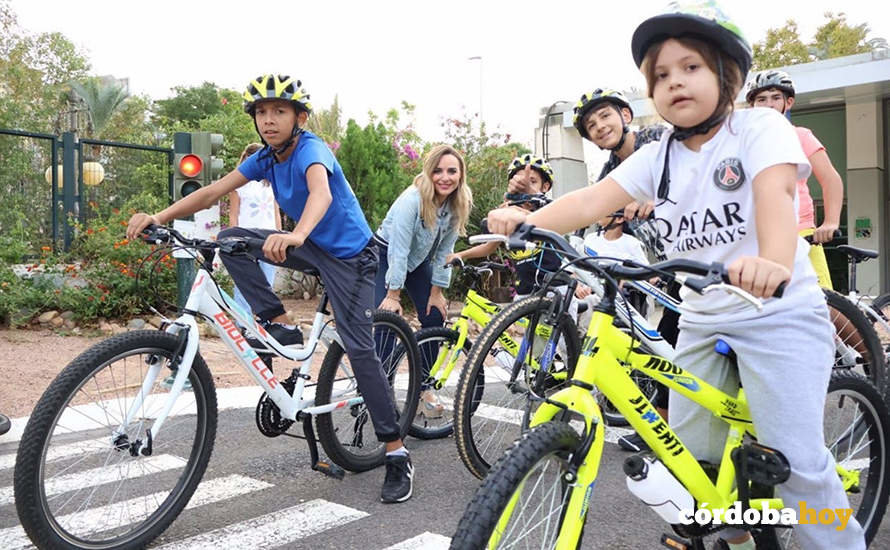 La delegada de Educación e Infancia, Narci Ruiz (al fondo), con menores y las nuevas bicicletas