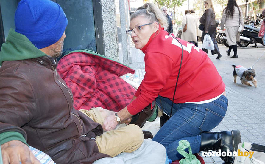 Una voluntaria de Cruz Roja atiende a una persona sin hogar