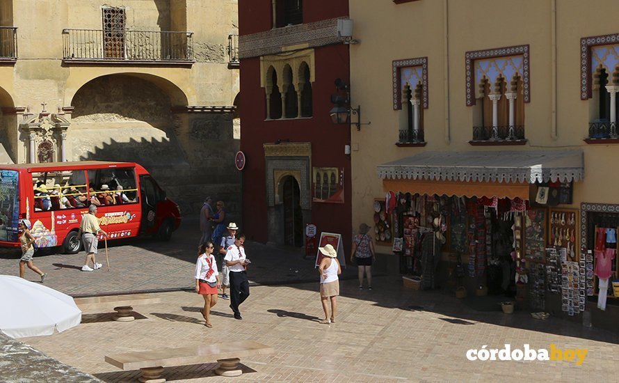 Turistas en el entorno de la Mezquita Catedral con el bus turístico de fondo