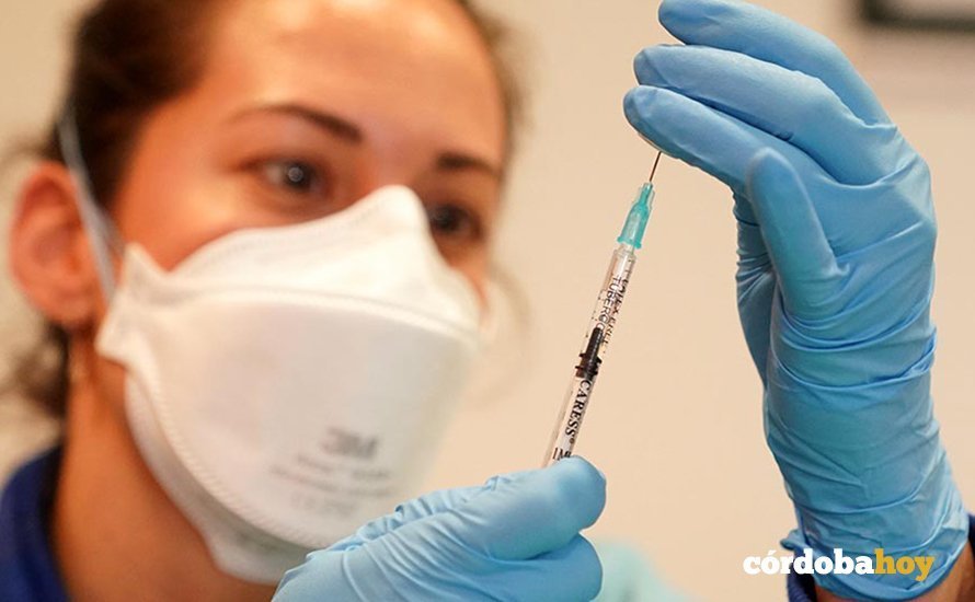 Una profesional sanitaria se dispone a administrar una vacuna