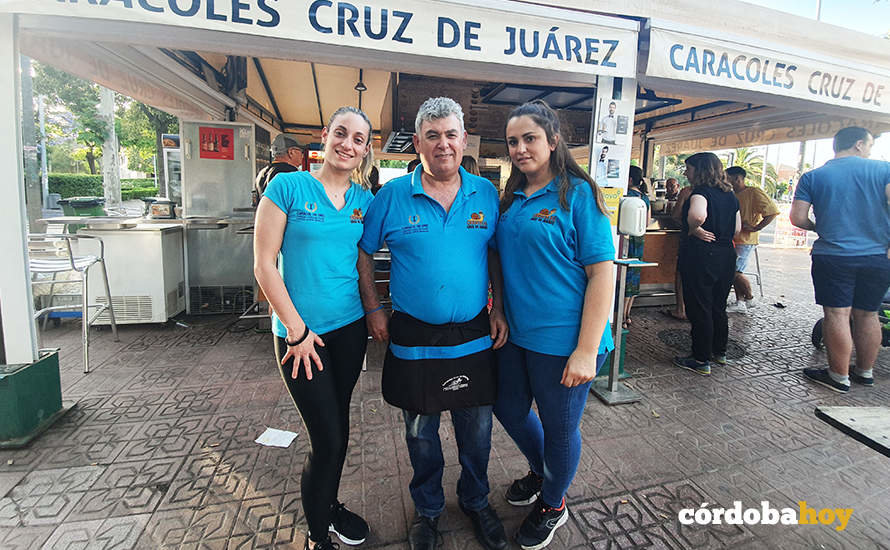 Rafael Muñoz Soro ante su puesto de caracoles en Cruz de Juárez junto a Lorena y Cristina