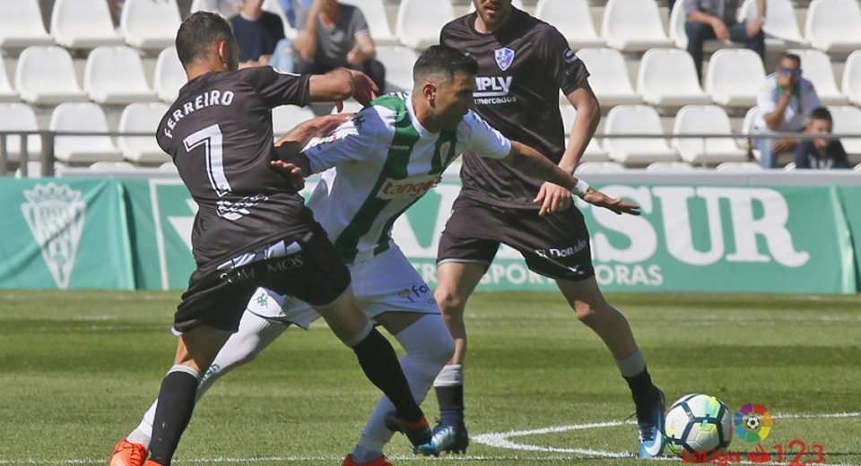 Reyes intenta zafarse de dos rivales del Huesca