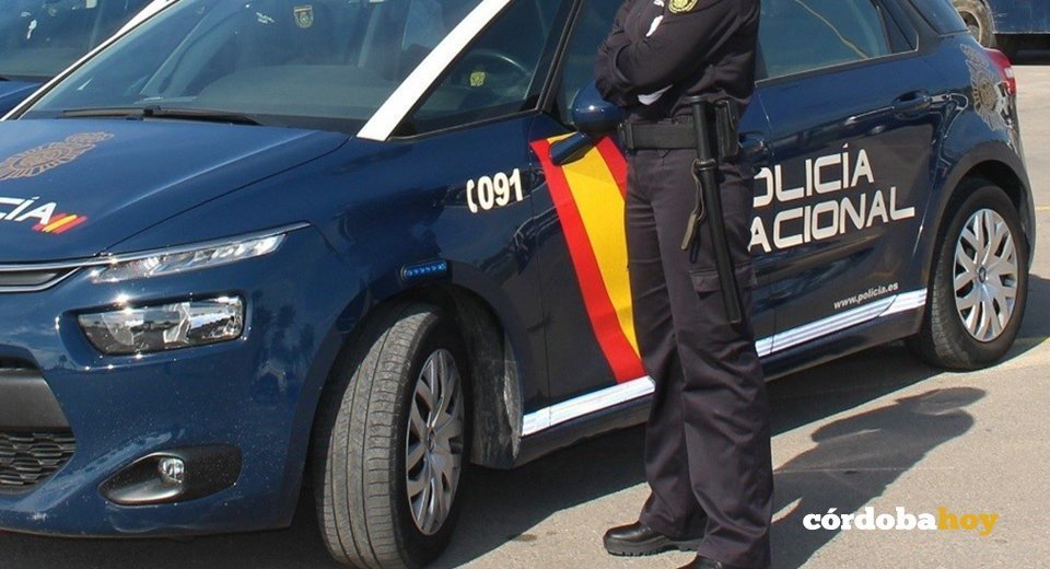 Agente de Policía junto a un vehículo policial