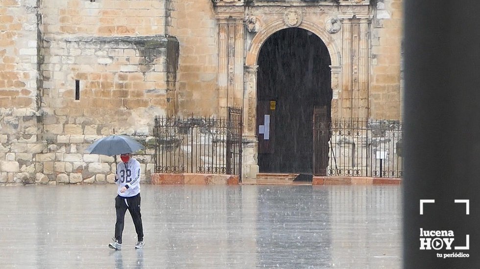 Un persona pasea por la Plaza Nueva de Lucena bajo la lluvia