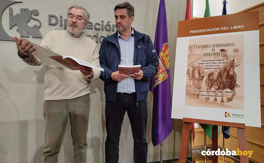 El delegado de Memoria Democrática y Cooperación de la Diputación, Ramón Hernández (dcha.), junto a Luis Naranjo, ojea el libro 'La guerrilla antifranquista en Sierra Morena'