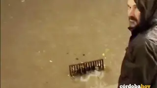 Un vecino de C&oacute;rdoba alivia la inundaci&oacute;n de su calle liberando el rejado de la alcantarilla IMAGEN SACADA DE UN VIDEO VECINAL