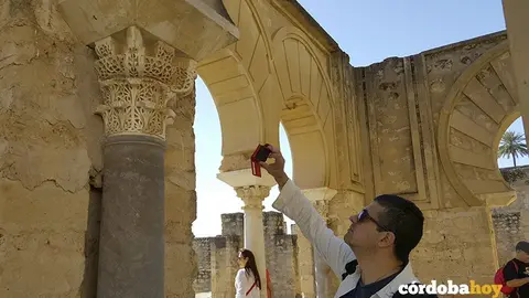 Un turista fotograf&iacute;a un capitel de Medina Azahara