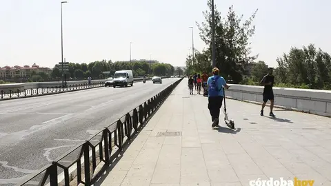 Mujer con patinete y un hombre haciendo f&uacute;ting en el Puente de San Rafael