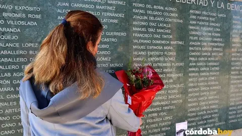 Una mujer coloca flores en el Muro de la Memoria en C&oacute;rdoba, en una imagen de archivo