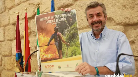 Miguel &Aacute;ngel Torrico con el cartel de la campa&ntilde;a preventiva de incendios