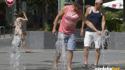 Dos hombres tratan de refrescarse en los chorros de Las Tendillas, en una foto de archivo
