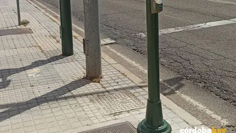 Uno de los postes con un pulsador a baja altura pensado para sillas de ruedas