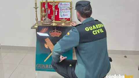 Agente de la Guardia Civil con los objetos robados en la ermita de Los &Aacute;ngeles de Baena FOTO GUARDIA CIVIL