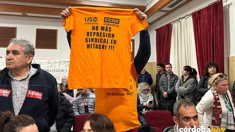 Un trabajador de Hitachi muestra una camiseta naranja de su lucha laboral en el Pleno ordinario de febrero de 2026