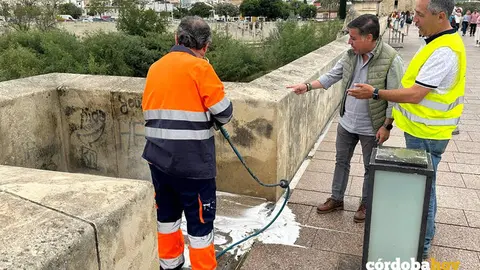 Miguel Ruiz Madruga (centro) con templa la eliminaci&oacute;n de las pintadas vand&aacute;licas del Puente Romano FOTO SADECO