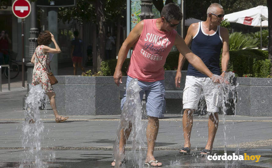 Dos hombres tratan de refrescarse en los chorros de Las Tendillas, en una foto de archivo