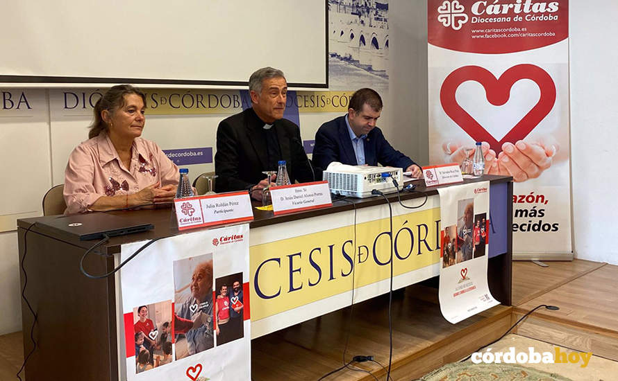 El vicario de la Diócesis (centro), entre el director de Cáritas Córdoba y una participante en los programas de entidad eclesial, Julia Roldán, durante la presentación del balance de 2023