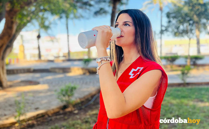 Voluntaria de la Cruz Roja hidratándose contra el calor